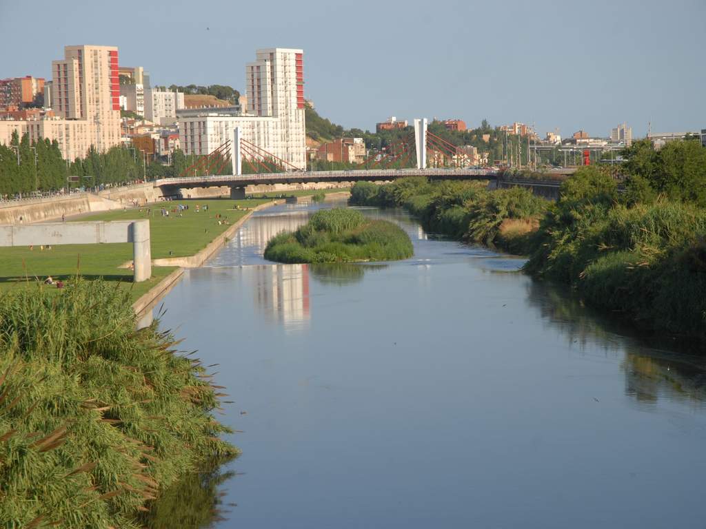 Vista del río Besòs a su paso por Santa Coloma de Gramenet, con el parque fluvial y la pasarela